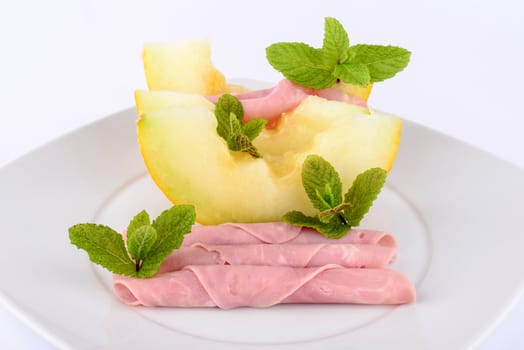 Ham and melon on white background.