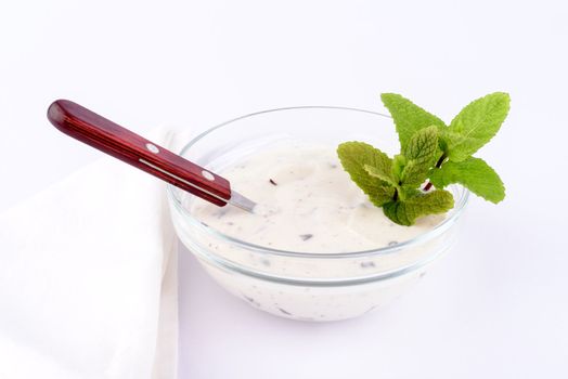 Natural yoghurt with pieces of chocolate in a small glass.