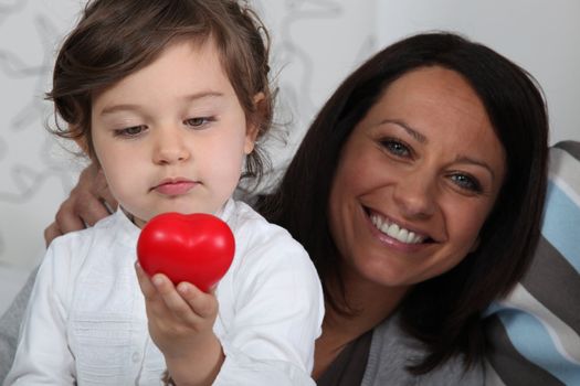 Little girl holding plastic heart