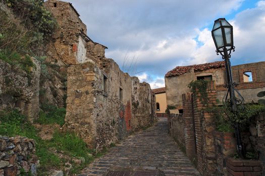 Paved medieval street with ruined house in Savoca village, Sicily, Italy