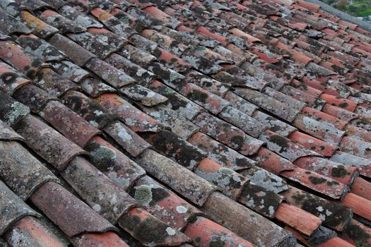 Background of old roof tiles covered with lichen and moss