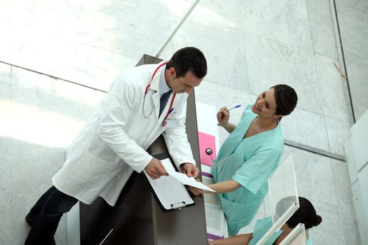 Medical secretary showing record to doctor