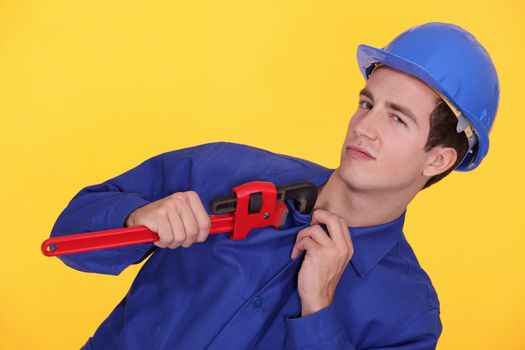 Tradesman's uniform stuck in the jaw of a pipe wrench
