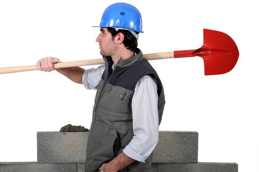 craftsman carrying a shovel on his shoulder