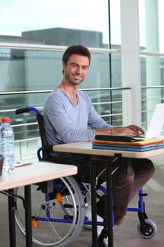 Man on laptop in wheelchair