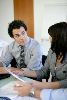 Worker explaining document to colleague