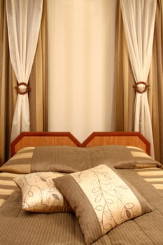 fragment of an interior of a bedroom. two beds and two pillows, vertical shot