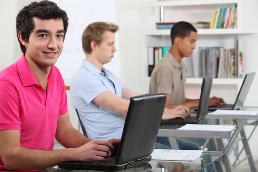 Young men working on their assignments in a computer lab