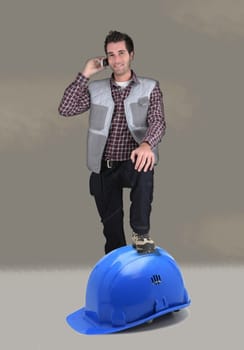 Builder resting foot on giant helmet