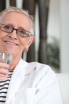 portrait of a seated mature lady holding a glass of water