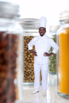black cook amid giant jars filled with food goods