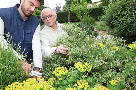 young man gardening with older woman