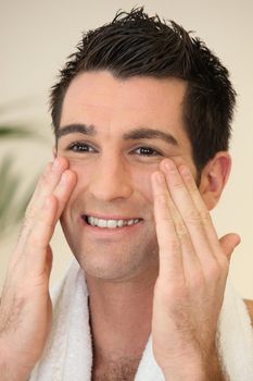 Portrait of a smiling man applying cream
