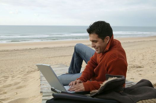 Man using his laptop at the beach
