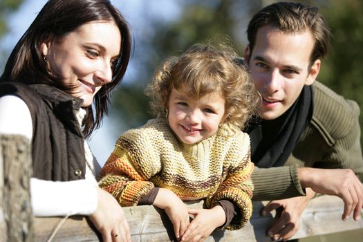 Young family leaning against fence