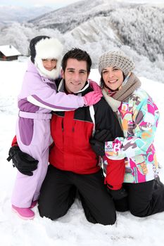 Young family on a snowy mountain