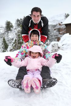 Family sledging downhill