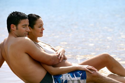 Embraced couple laid on the sand