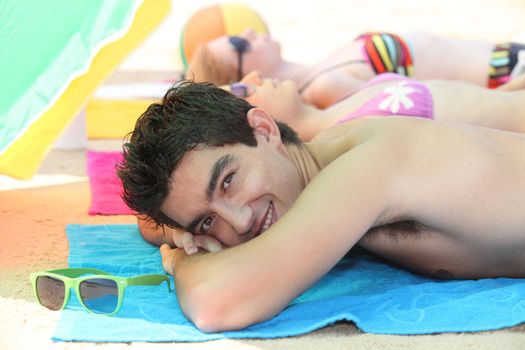 Three young people sunbathing