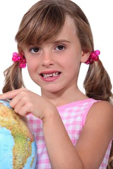 Young schoolgirl pointing to a destination on a globe
