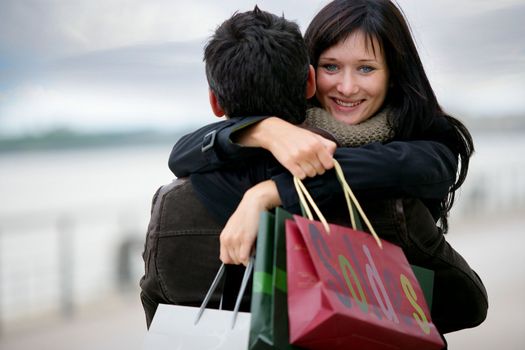 Couple with shopping bags hugging