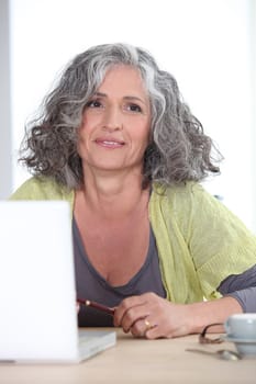 Gray-haired woman in front of laptop computer
