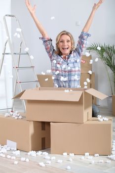 Woman crouching in front of stacked cardboard boxes
