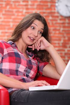 young woman having fun on her laptop at home