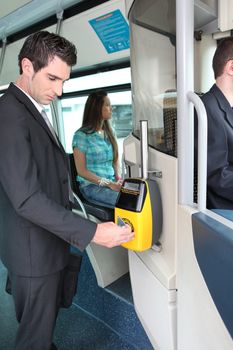 Man validating ticket on tram