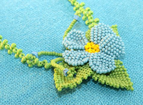 clay handmade blue bead pendant flower on a blue background