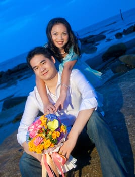 close up attractive young girl embracing her handsome boyfriend on the beach at dusk