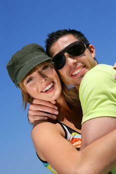 Couple hugging against a blue sky