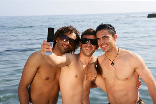 Young men taking pictures at the beach