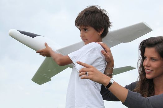 Mother and son playing with a large model toy aeroplane