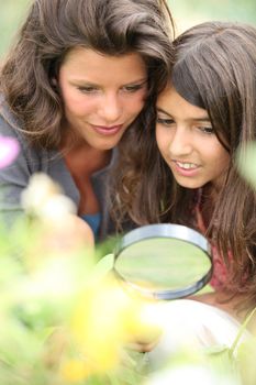 Mother and daughter with a magnifying glass