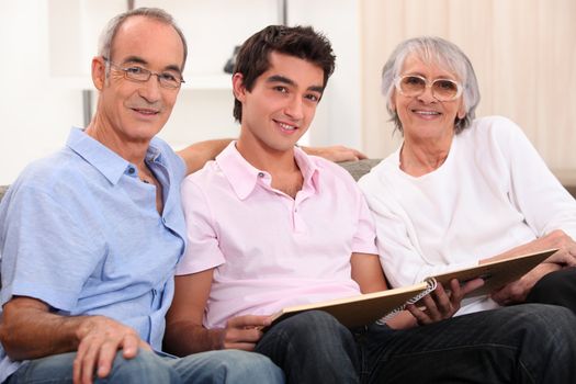 grandparents and grandson skimming through album