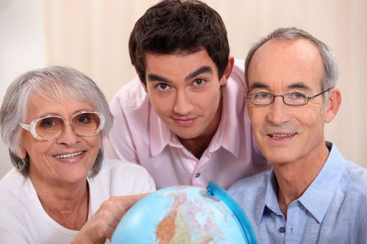 Grown-up family looking at a globe