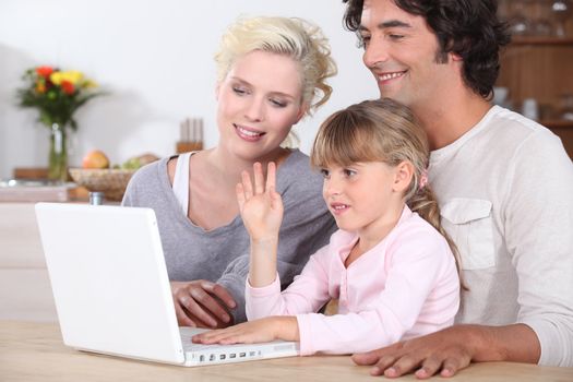 parents and their little girl having fun on the Internet