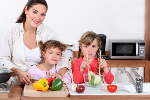 mother and daughters preparing salad