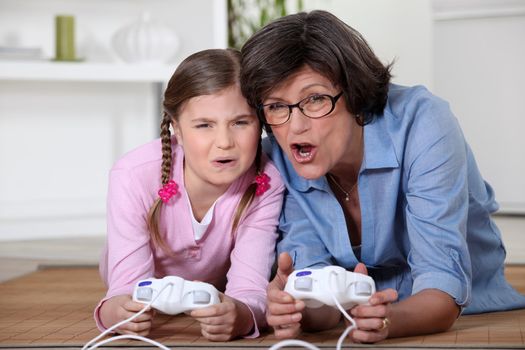 Little girl playing a computer game with her grandma