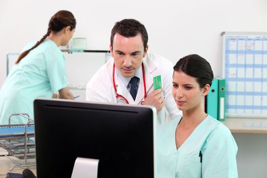 Doctor and nurse checking details on a computer