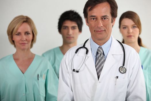 A doctor and three nurses behind him, all looking at us.