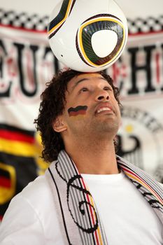 Football fan balancing ball on head