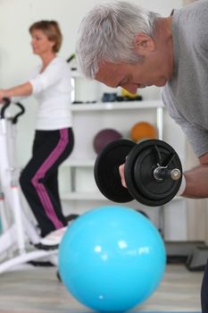 Older couple working out in gym