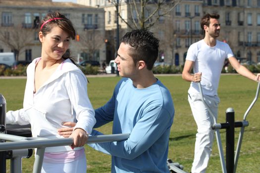 Three friends on outdoor gym machines