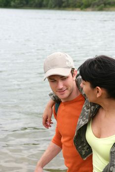 Young couple walking by a river