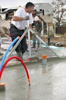 Workers pouring a cement foundation