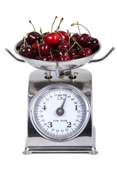 Scale measuring the weight of a bunch of cherries