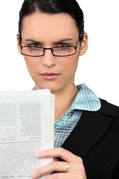 Woman in glasses reading a newspaper