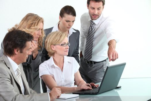 Business team sitting around a laptop computer